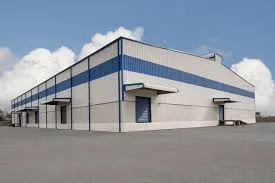 White steel-clad warehouse with a blue band and roller-shutter loading doors