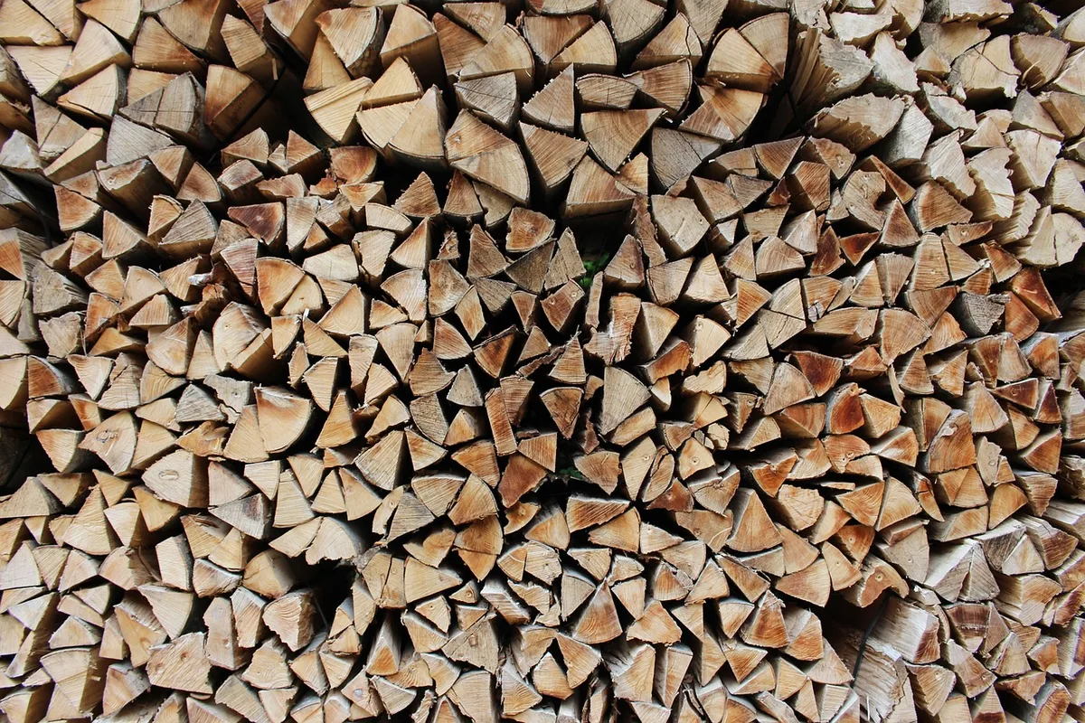 Stack of split firewood pieces seen end-on, wedge-shaped with visible grain