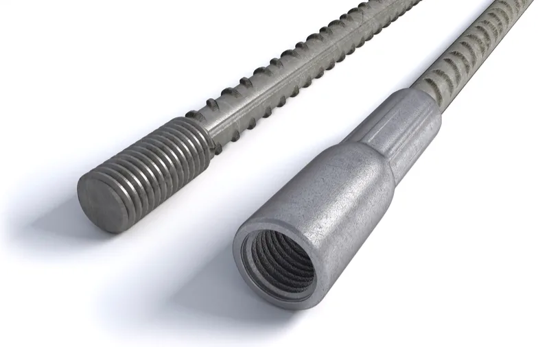 Rebar with a threaded end beside a coupler sleeve on a second bar, its internal thread visible