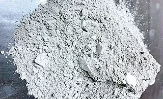 Heap of loose grey cement powder with a few small lumps
