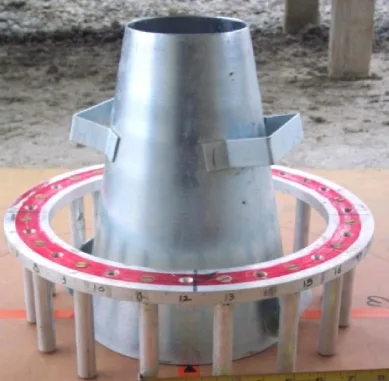 Galvanised slump cone standing upright inside a red J-Ring with numbered steel rods, on a board