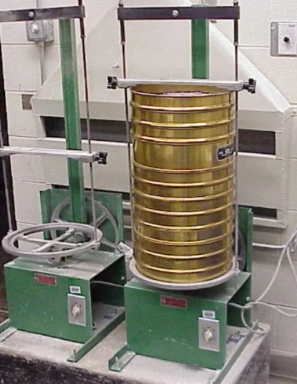 Stack of brass test sieves clamped in a mechanical sieve shaker