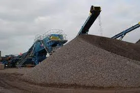 Stockpile of crushed aggregate beside a conveyor and screening plant