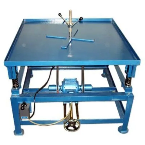Blue steel vibrating table mounted on springs with an electric motor underneath and a clamping frame on top