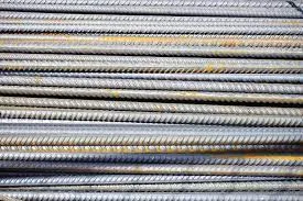 Bundle of ribbed steel rebar with patches of orange surface rust